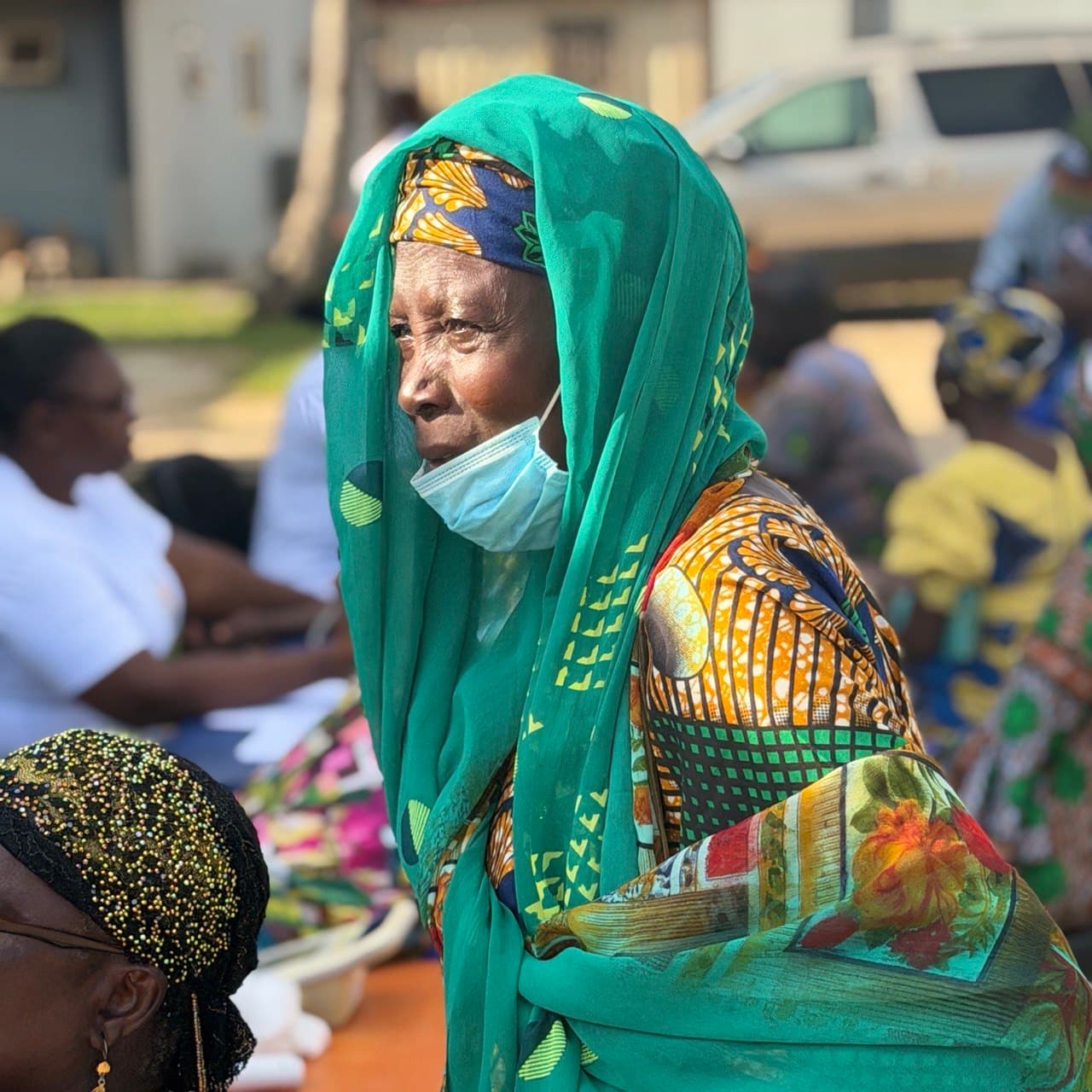 An elderly man in traditional Nigerian clothing at a local market